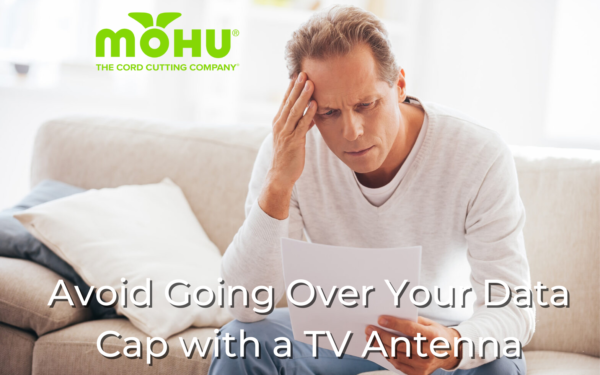 Avoid Going Over Your Data Cap with a TV Antenna, man sitting on couch looking upset with bill in his hands, mohu logo