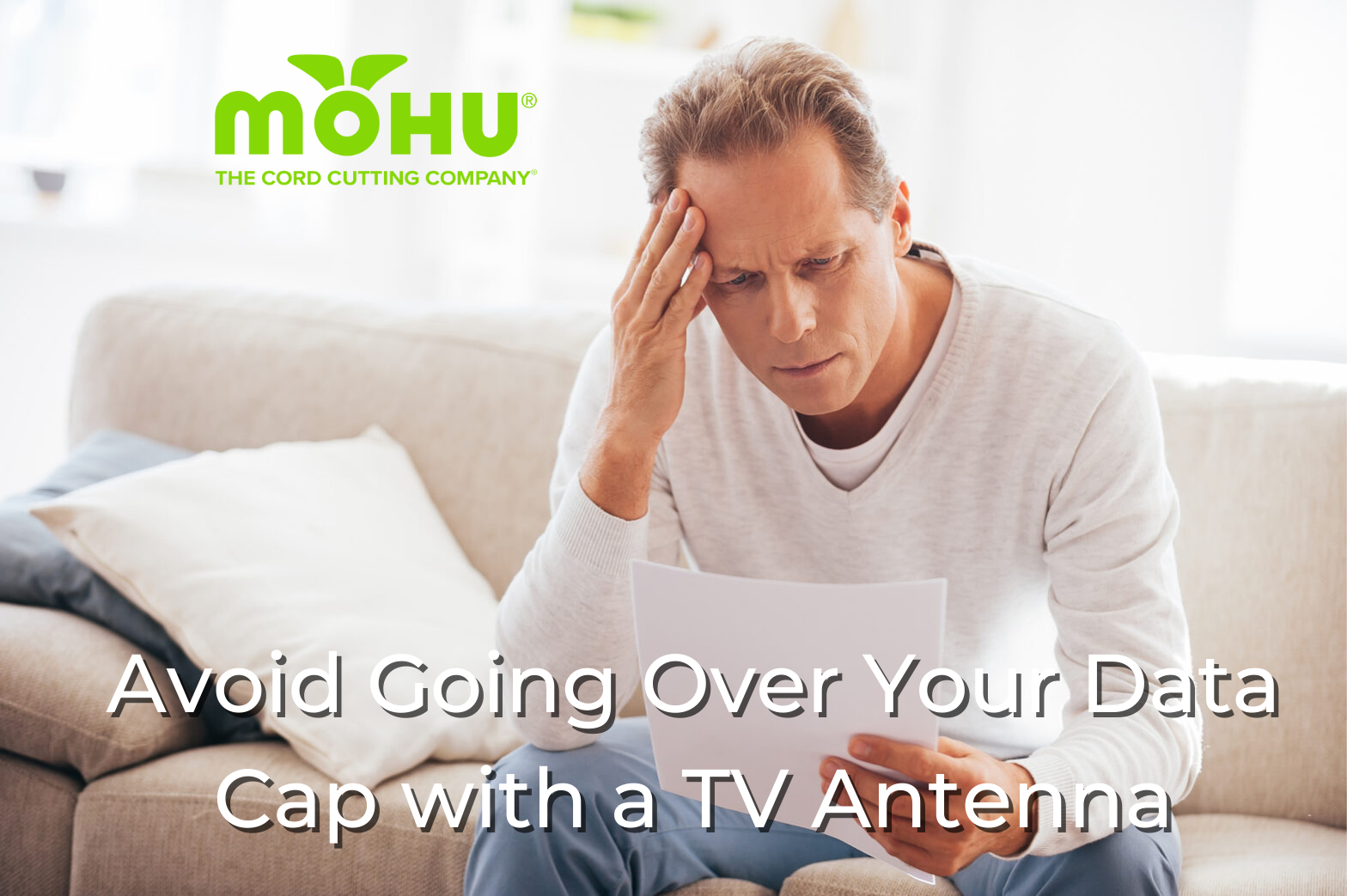 Avoid Going Over Your Data Cap with a TV Antenna, man sitting on couch looking upset with bill in his hands, mohu logo