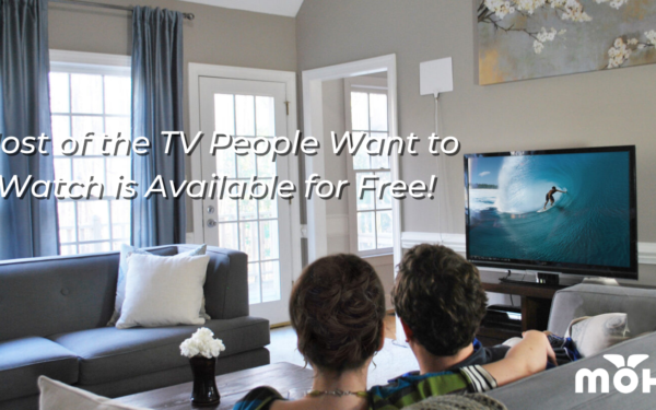 Couple sitting on the couch in front of a television with a Mohu antenna and the copy "Most of the TV People Want to Watch is Available for Free"