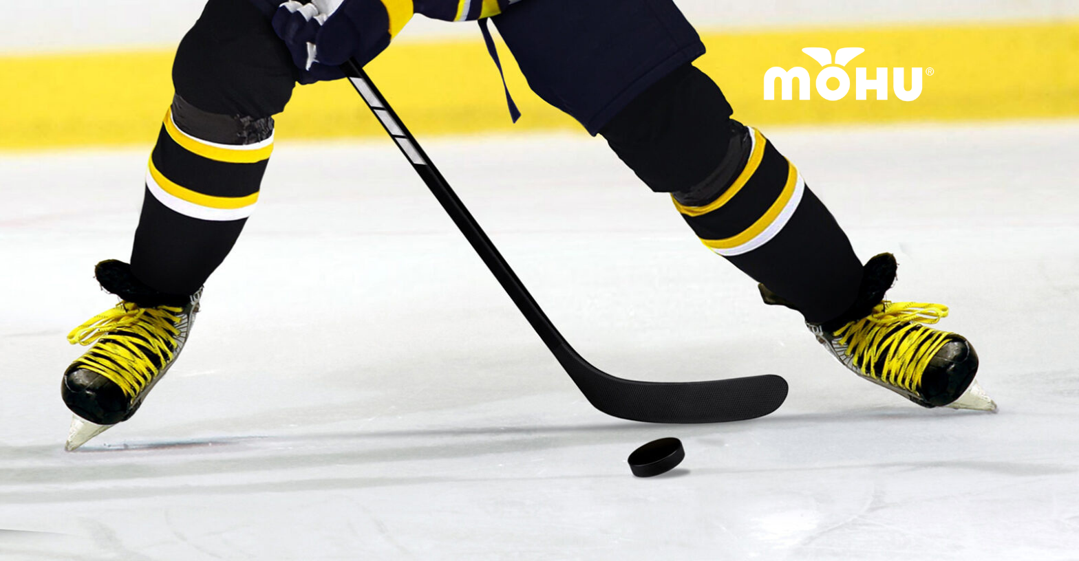 Hockey player on the ice hitting the puck with Mohu logo